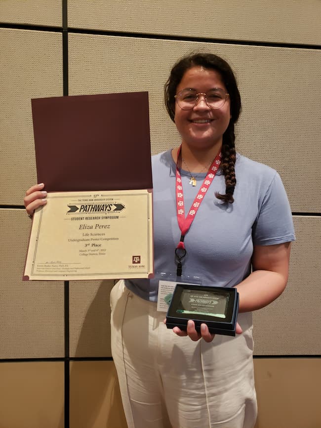 Eliza Perez poses with award certificate from Pathways Research Symposium 